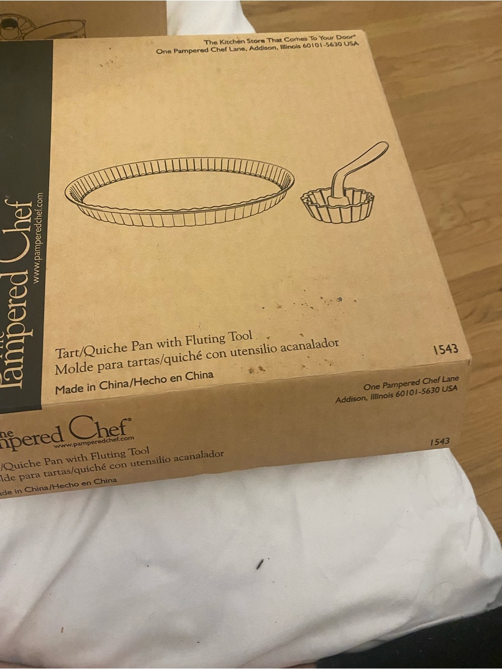 In box and never used the pampered chef tart pan with fluting tool